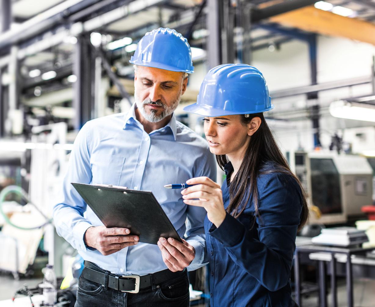Dos ingenieros en planta tomando notas